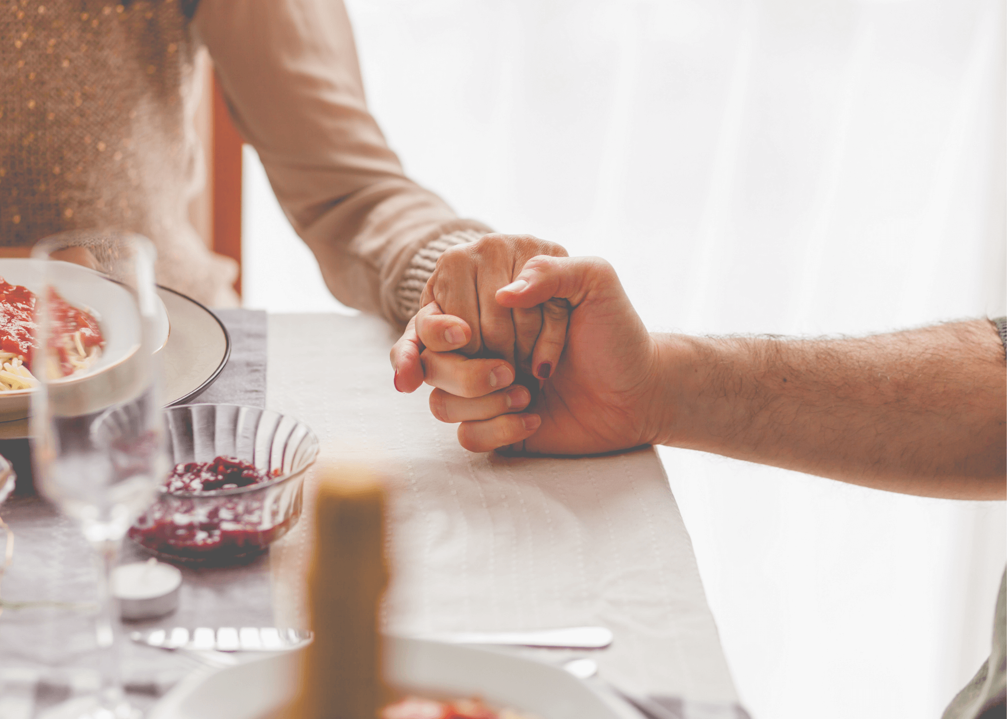 Couple holding hands at the dinner table; Alles Law